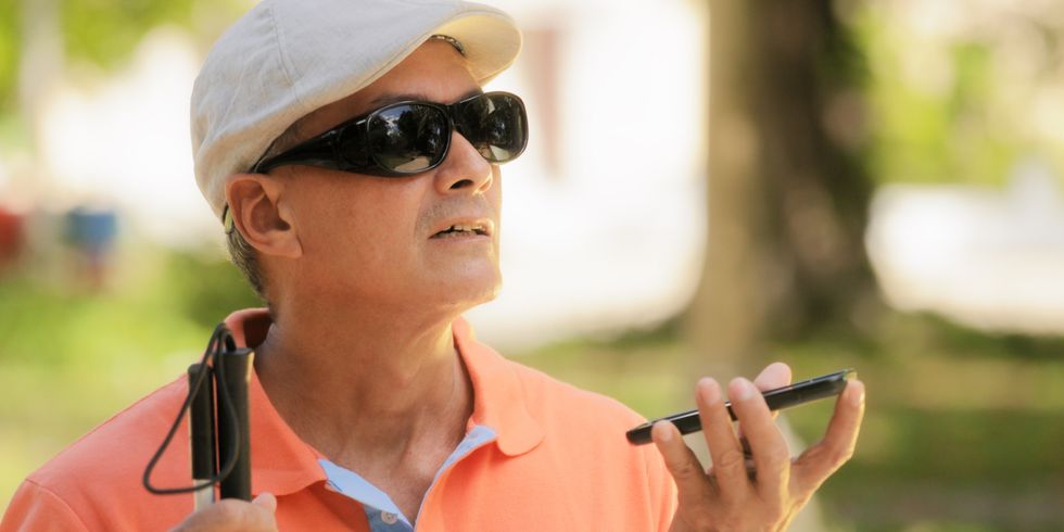 Blinder Mann spricht in sein mobiles Telefon