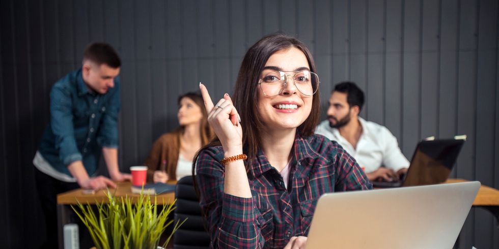 Frau vor Laptop hebt den Finger