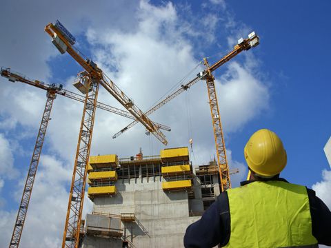 Baustelle mit Kränen und Bauarbeiter