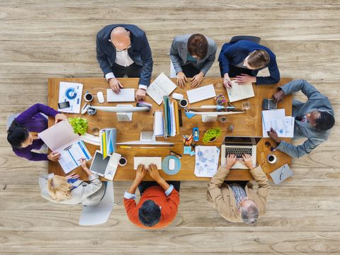 Menschen von oben sitzen an einem Tisch und arbeiten